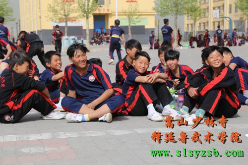 嵩山少林武术学院的学生在经过武术课后，在训练场上休息，脸上不由的露出了满意的幸福