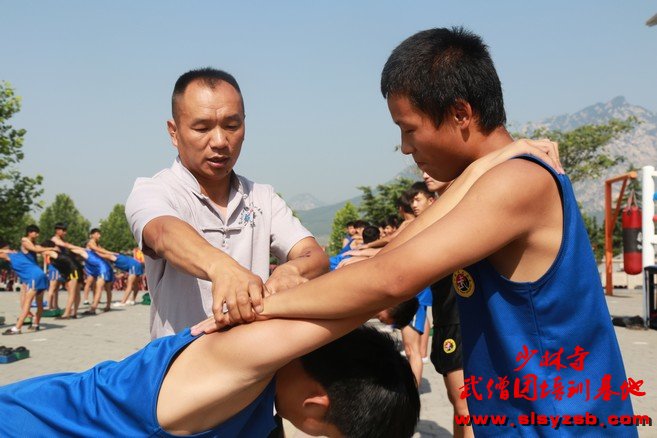 少林武术学校教练帮助学员纠正错误姿势